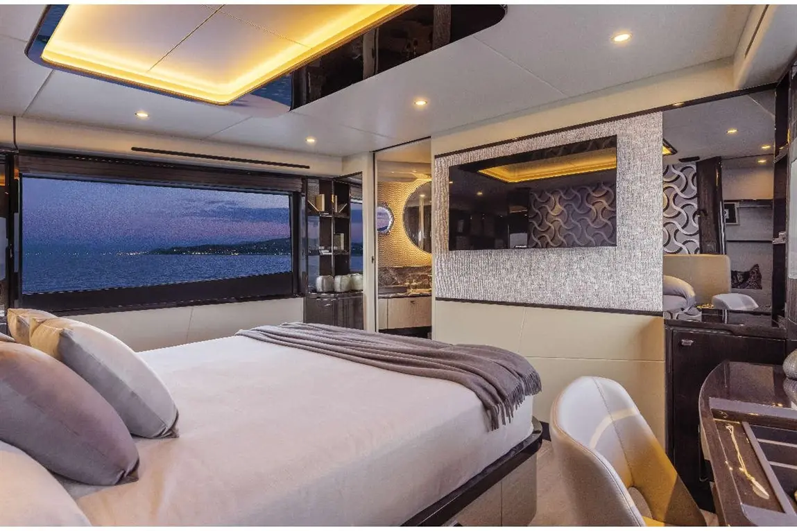 Luxurious yacht interior featuring a spacious bedroom, elegant decor, and a stunning sea view through large windows.